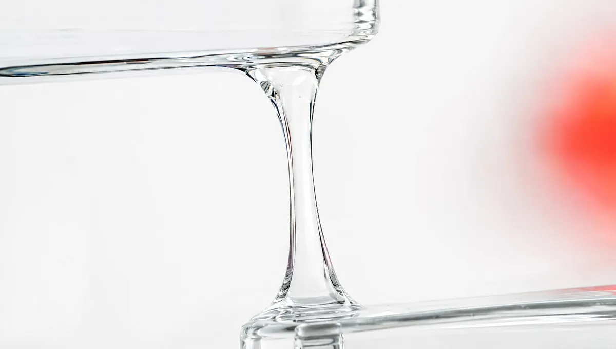 Symbolbild: Faden aus klarem, zähflüssigem Gel zwischen zwei Glasflächen